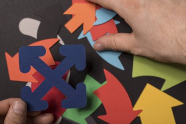 Renkli kağıt okları, yön ve seçim kavramını düzenleyen eller