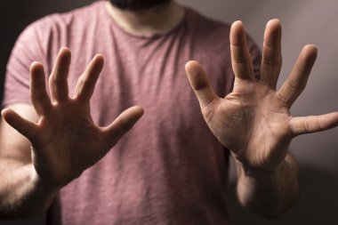 Elleri açık hareket eden adam durduğunu, önlediğini ya da koruduğunu gösterir.