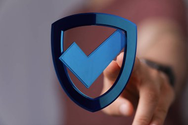 İşaretli Sembol ile Mavi Kalkan 'ı gösteren kişi