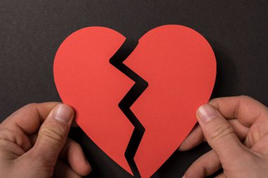 Kırık bir kalbi tutan eller aşkı ve kaybı simgeliyor.