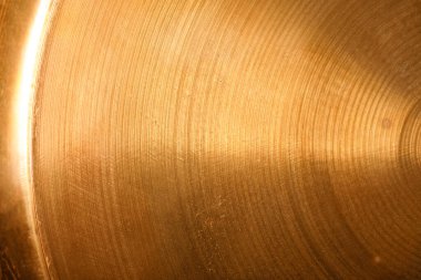 Radyal çizgileri olan dairesel altın metal yüzey sıcak bir doku yaratıyor..