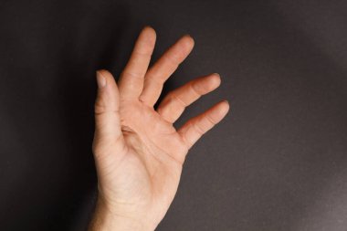 Siyah arkaplanda açık bir el hareketi, duygu ve konsepti gösteriyor