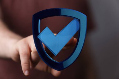 İşaretli sembollü bir kalkan simgesini tutarken