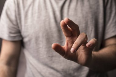 Parmaklarını gösteren, küçük ölçü jesti ya da odak noktasında çimdik atan bir adam.