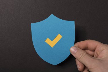 Kontrol işareti olan bir kalkanı tutmak, güvenlik kavramı..