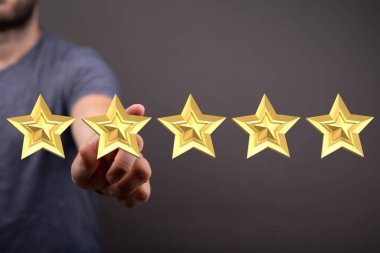 Adamın elinde beş altın yıldız, derecelendirme ve kalite konsepti var.