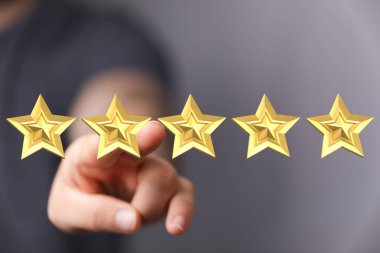 Beş altın yıldızı işaret ederek, mükemmel dereceyi temsil ediyor.