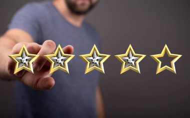 Değerlendirme ve değerlendirme için altın yıldızları sunan adamın eli..