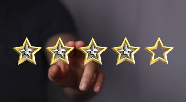 Değerlendirmede derecelendirmeyi ve kaliteyi temsil eden altın yıldızlara dokunmak