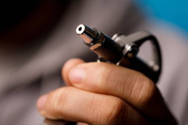 Hassasiyet çalışması için bir alet hortumunu tutan elin yakın çekimi