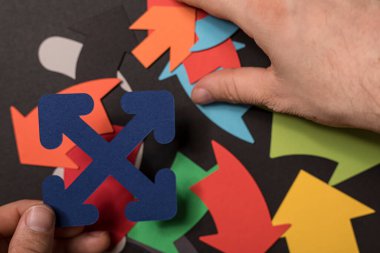 Renkli kağıt okları, yön ve seçim kavramını düzenleyen eller