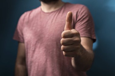 Mavi arka planda onaylanmış bir jest yapan adam