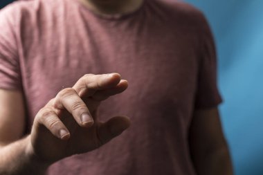 Adamın eli bulanık mavi bir arkaplanı işaret ediyor.