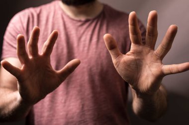 Elleri açık hareket eden adam durduğunu, önlediğini ya da koruduğunu gösterir.