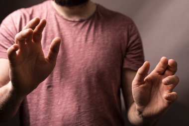 İki eliyle uzanan bir adam sunar ya da alıyormuş gibi..