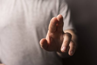 Adamın eli ileriye bakıyor, görünmez bir şeye dokunuyor.