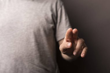 Adam odaklanmış ve beklenen bir şeyi işaret ediyor.