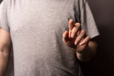 Tarafsız arka planda yumuşak gölgeli insan eli işareti.