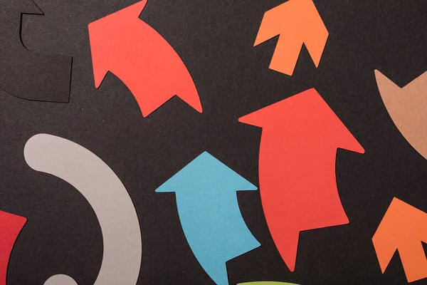 Koyu arkaplan, yön ve konsept üzerine renkli kağıt okları