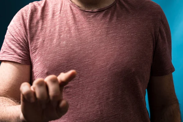 Elinde işaret eden, kırmızı tişört giyen bir adam.