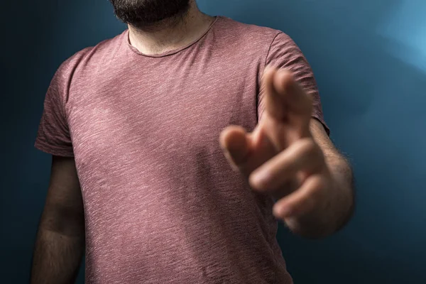 Adam kamerayı ciddi bir ifade ve hisle işaret ediyor.