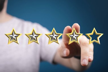 İnsanın eli dört yıldız seçiyor. Müşteri memnuniyetini ve derecelendirmeyi simgeliyor.