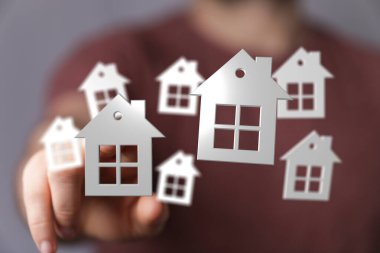 Minyatür beyaz evler koleksiyonuna uzanıyor.