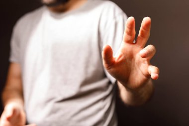 Adamın el hareketi karanlık bir arka plana odaklanıyor.