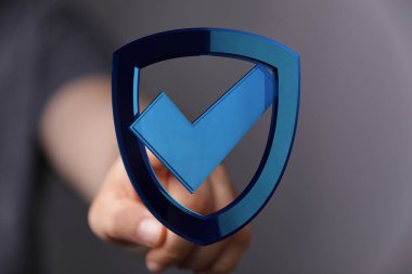 Güvenlik kavramı ve kontrol işareti ile dijital kalkanlara dokunmak.