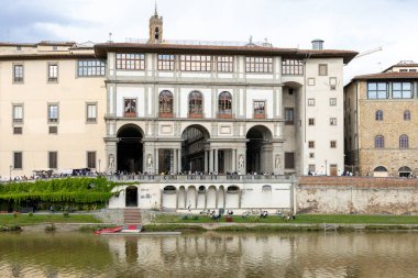 Floransa, İtalya - 10 Mayıs 2025: Arno Nehri 'nin karşısındaki Uffizi Galerisi, turistlerin nehir kenarındaki teras boyunca toplandığı yer.