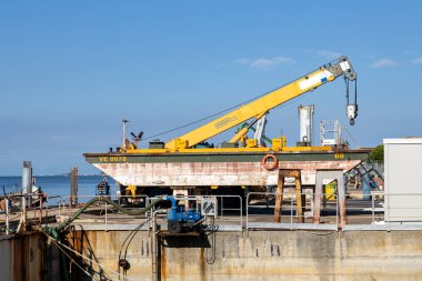 Pellestrina, Venedik, İtalya - 27 Ekim 2025 ACTV tersanesine yanaşmış bir vinci olan bakım mavnası