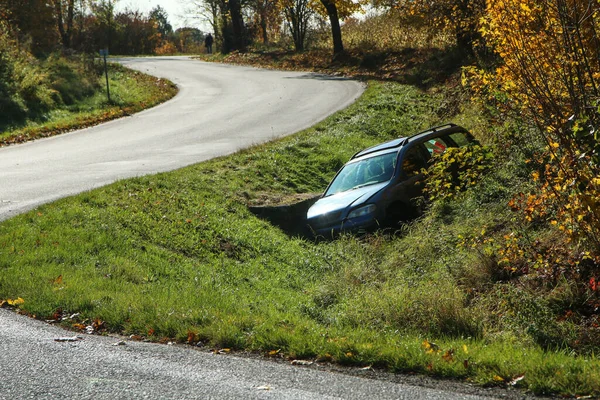 The car in the ditch by the road after the traffic accident. Abandoned and waiting for tow.