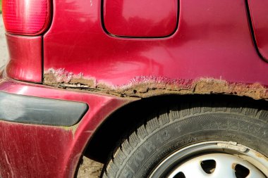 Eski arabanın delikli ve paslı çamurluğunun ayrıntıları. Pasa karşı zayıf korunmanın bir örneği..