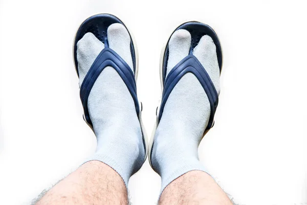 Çoraplı kıllı erkek bacakları ve ayaklarında parmak arası terlikler. Kötü zevk ve moda için sembol.