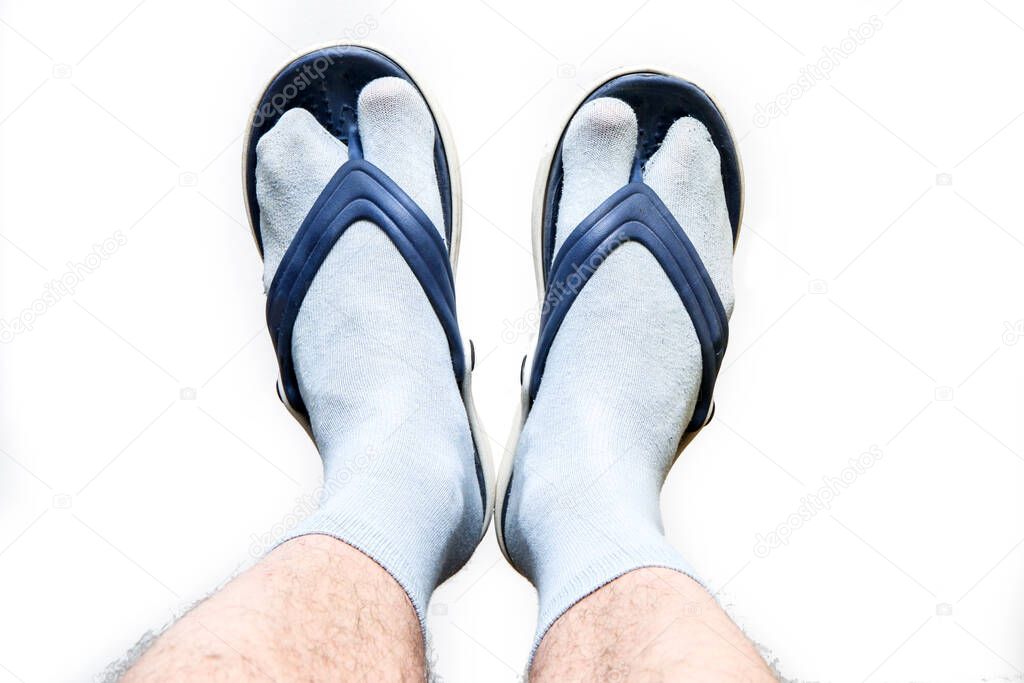 The hairy man legs with socks and flip flops on the feet. Symbol for bad taste or fashion style.