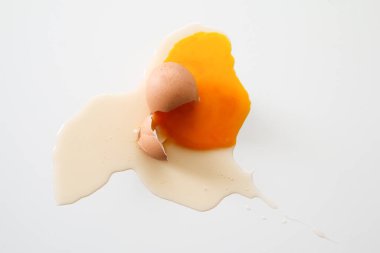 Düşen organik yumurta, yumurta kabuğu kırılmış, yumurta sarısı ve beyaz akarsu içinde yatar..