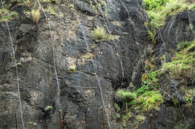 Kayadaki çelik ağların korunması ile ilgili bir detay. Düşen kayaların kimseye zarar vermeyeceğinden ya da bir şeye zarar vermeyeceğinden emin olmak için..