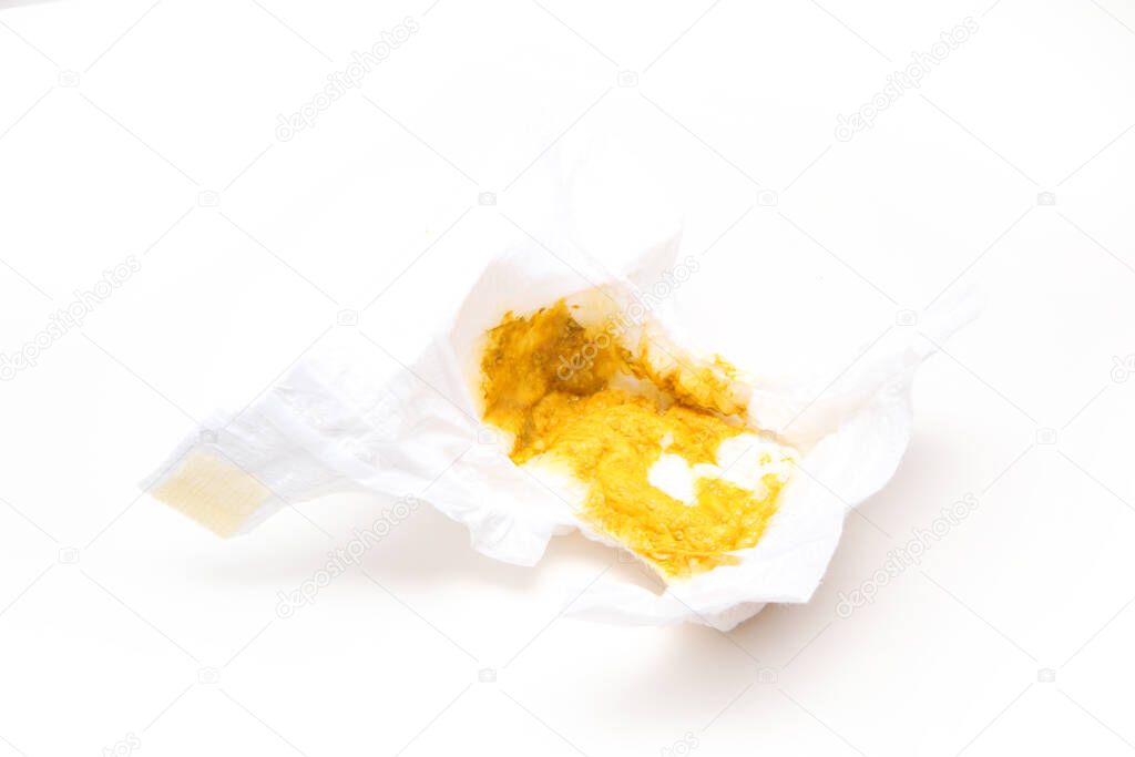 The dirty baby diaper full of sparse excrement, because the child has a diarrhoea. Isolated in a white background.