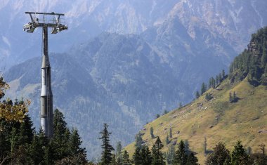 Hindistan 101225: Rohtang, Himachal Pradesh 'te kabin otomobil inşaatı, taşıma kulesi ve bölgede tepeye tırmanan bir işçiyi gösteriyor. Turizm altyapısı için kabin otomobil sisteminin genişletilmesi için Indias yatırımı.
