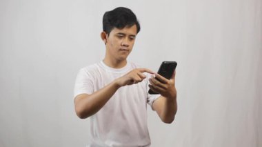 Asyalı adam akıllı telefonuyla sosyal medyada son haberleri arıyor.