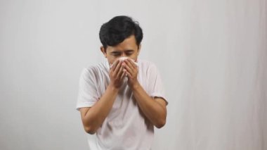 Grip olmuş Asyalı bir adam ağız ve burnu doku ile kaplamış.