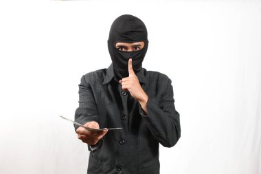 Kar maskesi takan ve takım elbiseli bir adam susturma hareketi yaparken para teklif ediyor..