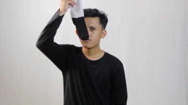 Adam çorapların keskin kokusunu içine çekmiş ve burnunu kapatmış. İzole edilmiş beyaz arka plan.