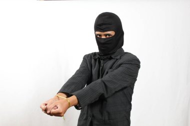 Maske takan hırsız ve siyah takım elbiseli yakalanmış. Beyaz arka planda küçük bir iple bağlanmış.
