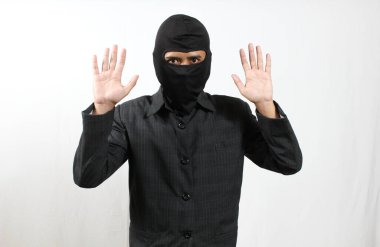 Kar maskeli bir hırsız yakalandı ve teslim oldu. İki elini de beyaz arka planda yalnız bıraktı.