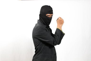 Maske takan hırsız ve siyah takım elbiseli yakalanmış. Beyaz arka planda küçük bir iple bağlanmış.