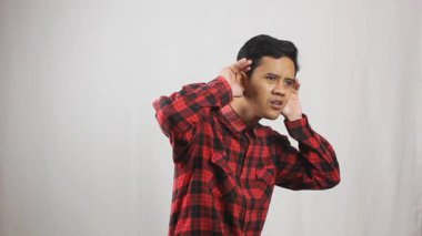 Asyalı bir adam beyaz arka planda izole edilmiş insanların konuşmalarını dinliyor.