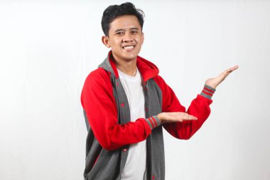 Takım ceketi giyen neşeli Asyalı adam gülümseyip sunuyor ya da beyaz arka planda avucu açık bir şeyin reklamını yapıyor..