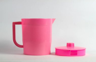 Açık kapaklı pembe plastik çaydanlık beyaz arkaplanda izole edilmiş.