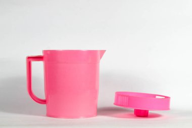 Açık kapaklı pembe plastik çaydanlık beyaz arkaplanda izole edilmiş.